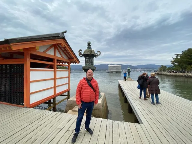 Kiko in a red jacket standing on a wooden pier by the water