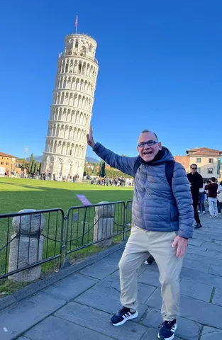 Kiko posing with his hand on the Leaning Tower of Pisa